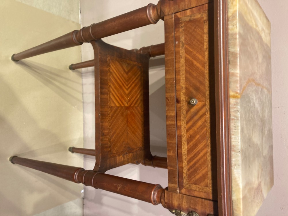 A rectangular French Louis XVI style side table featuring a marble top, chevron parquetry veneer, turned legs with gilt brass mounts, and a lower tier shelf. View II
