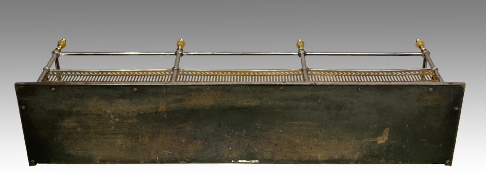 An antique polished steel hearth fender featuring a pierced brass lower gallery band, vertical support posts, and five turned brass urn finials along the top rail. View IV