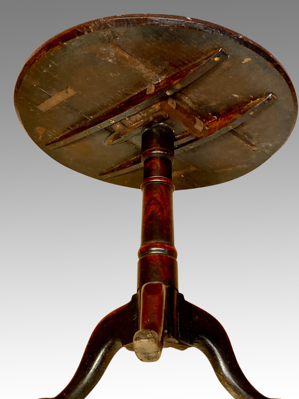 An 18th-century Georgian circular oak tripod table featuring a turned central pedestal column resting on three downswept legs. View IV