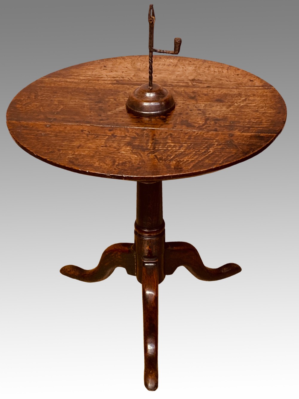 An 18th-century Georgian circular oak tripod table featuring a turned central pedestal column resting on three downswept legs. View V