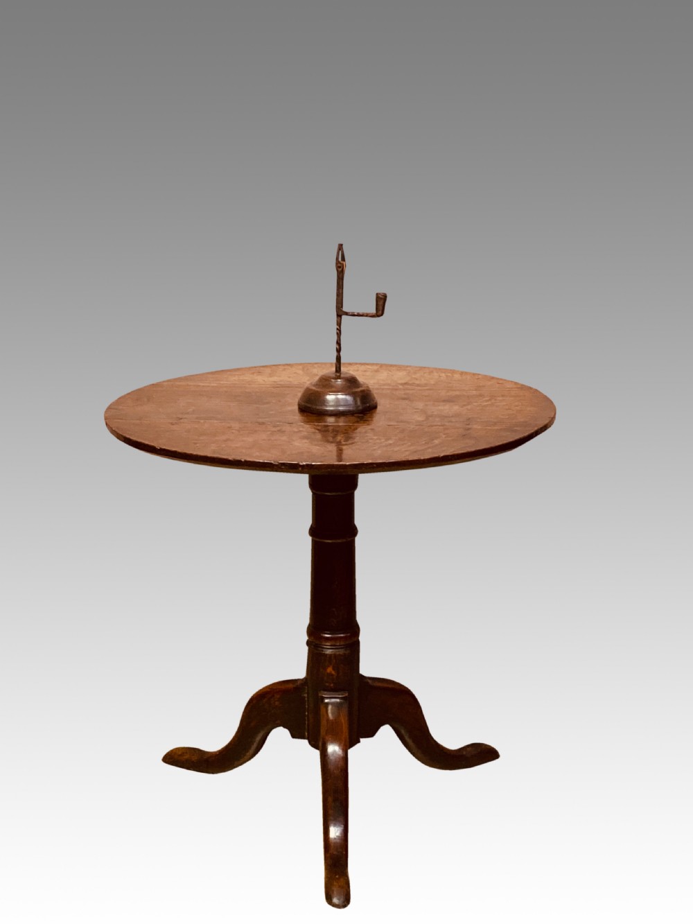 An 18th-century Georgian circular oak tripod table featuring a turned central pedestal column resting on three downswept legs. View VI