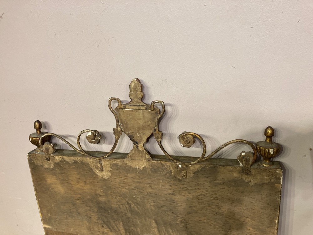 A tall Neoclassical French pier mirror featuring a green painted frame, gilded beaded trim, an urn motif cresting, and two hand-painted decorative panels. View VII