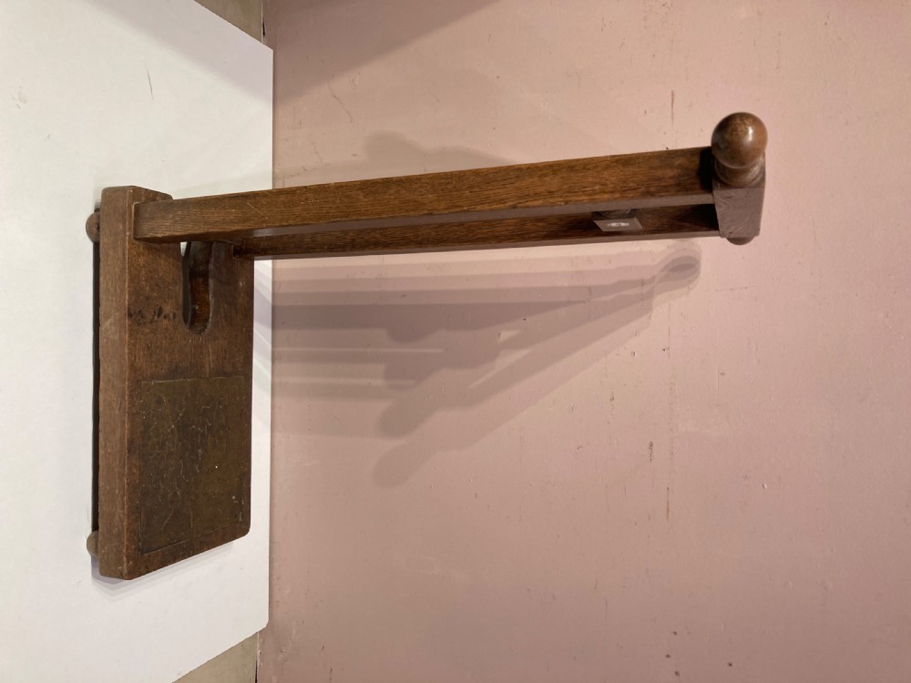 An antique freestanding oak boot jack featuring two top handles, a central vertical column, and a heel removal slot at the base. View VIII