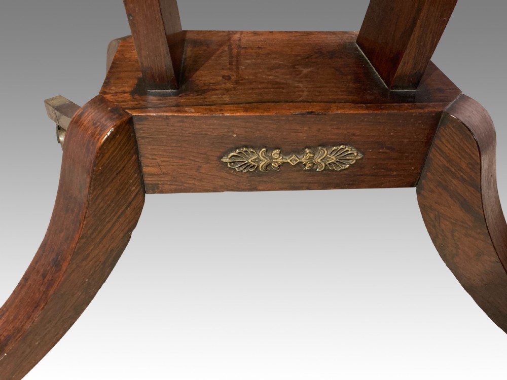 A Regency rosewood fold-over card table featuring brass inlay, a central pedestal support, and four curved sabre legs on brass castors. View III