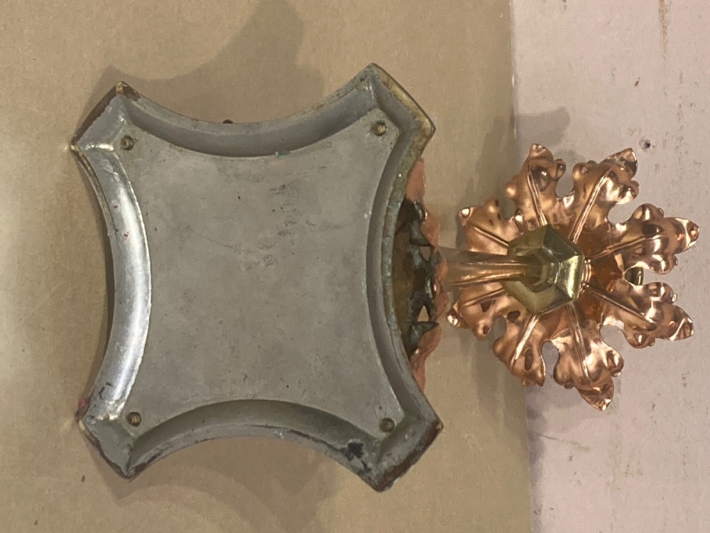 A pair of brass and copper Arts and Crafts candlesticks featuring stylised leaf sconces, slender tapered shafts, and pierced botanical bases. View IV
