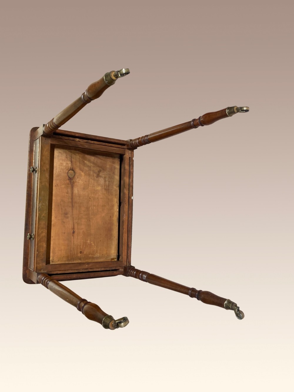 A Georgian mahogany writing table featuring a single drawer with two brass knobs, slender turned legs, and brass castors. View III
