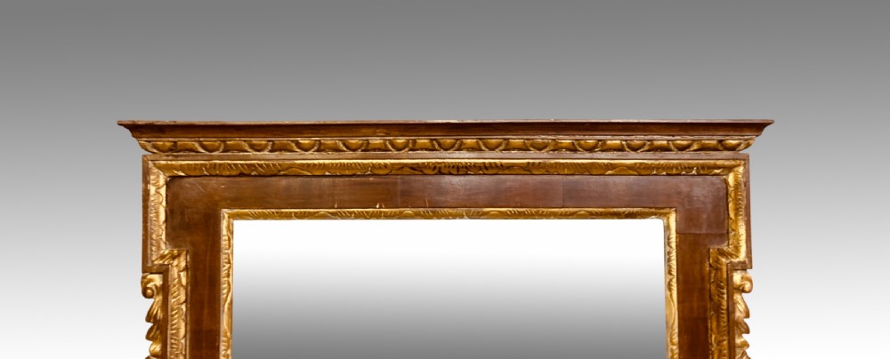 A rectangular 19th-century wall mirror crafted with polished mahogany veneer, bordered by carved gold giltwood trim and featuring a scalloped lower apron. View III