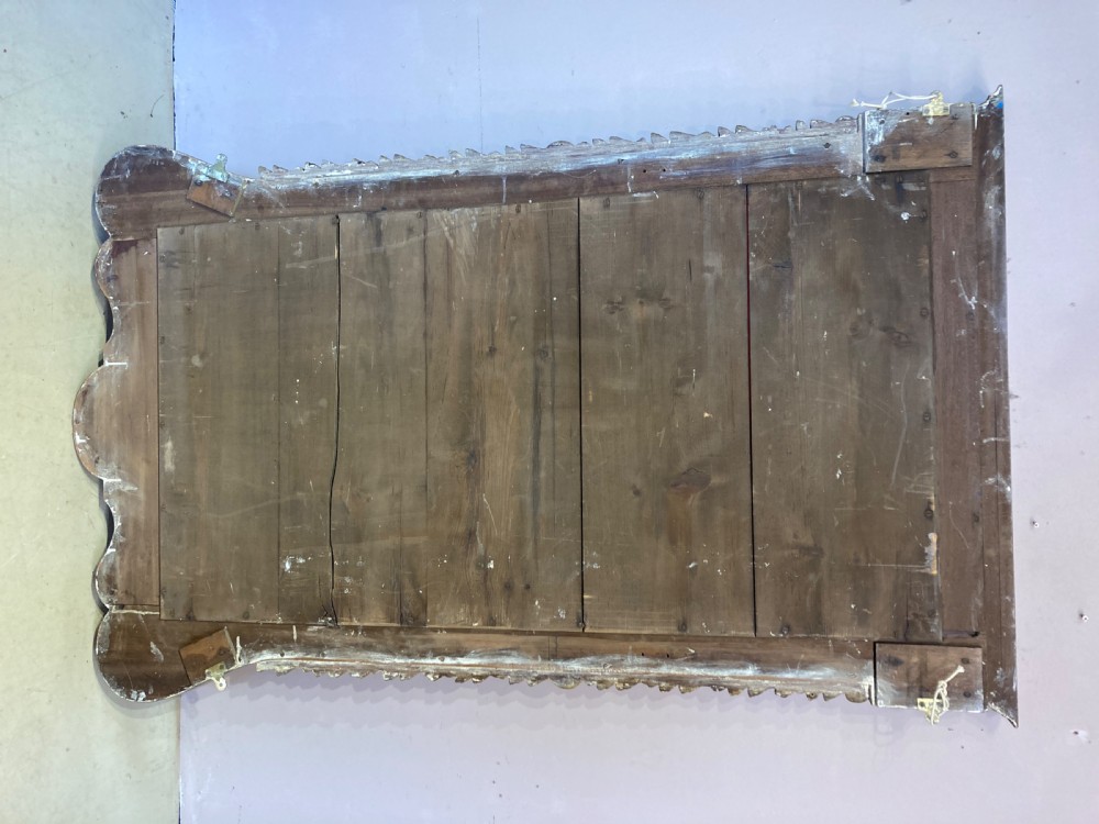A rectangular 19th-century wall mirror crafted with polished mahogany veneer, bordered by carved gold giltwood trim and featuring a scalloped lower apron. View V