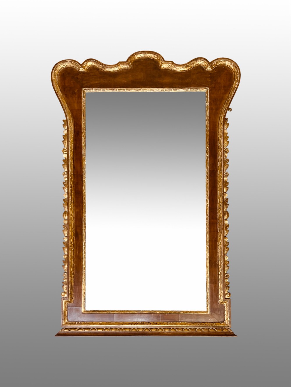 A rectangular 19th-century wall mirror crafted with polished mahogany veneer, bordered by carved gold giltwood trim and featuring a scalloped lower apron. View VII