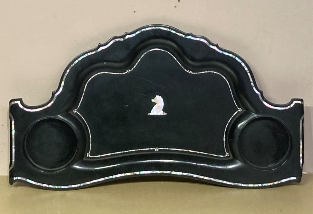 A black lacquered Georgian papier-mache tray featuring mother of pearl inlay along the scalloped rim and a central crest motif.