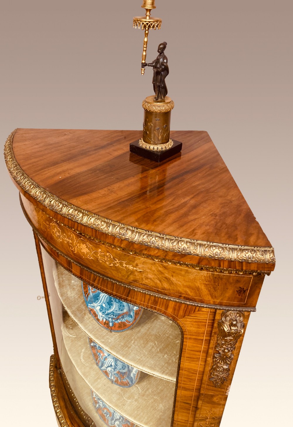 A pair of Victorian inlaid walnut corner cabinets featuring curved glass display doors, decorative floral marquetry, and gilt bronze mounts. View III