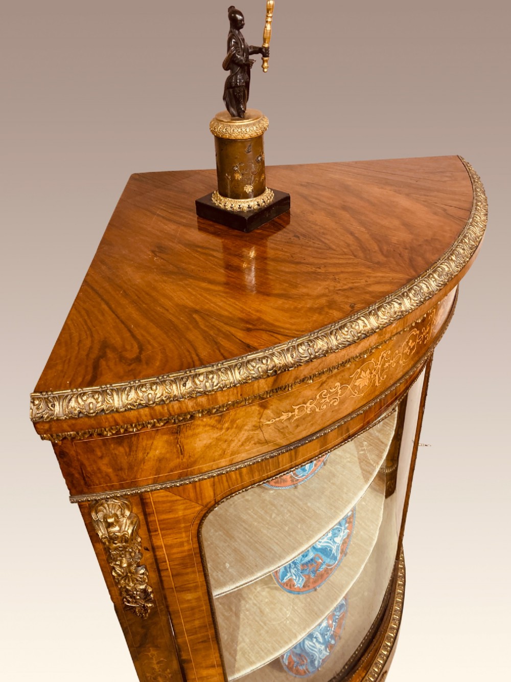 A pair of Victorian inlaid walnut corner cabinets featuring curved glass display doors, decorative floral marquetry, and gilt bronze mounts. View IV