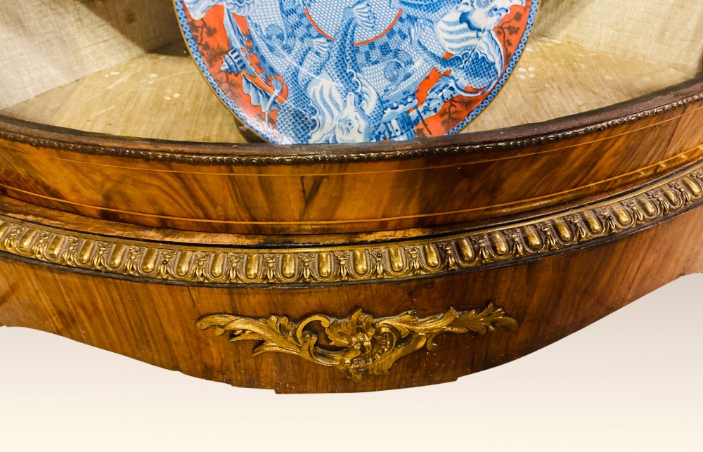 A pair of Victorian inlaid walnut corner cabinets featuring curved glass display doors, decorative floral marquetry, and gilt bronze mounts. View VIII
