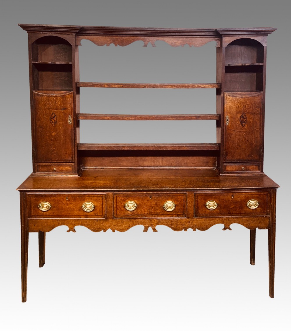 A Georgian oak Shropshire dresser featuring an open plate rack with side cupboards above a three-drawer base on tapered legs. View VII