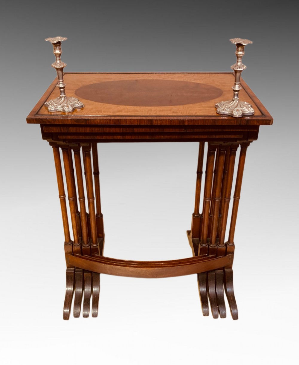 A set of four graduated mahogany nesting tables featuring oval satinwood centre inlays and slim turned dual-spindle legs. View VI