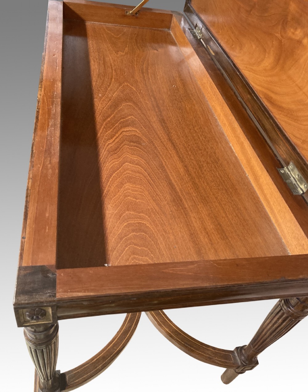A 19th-century rosewood rectangular music bench featuring a cream upholstered seat, fluted legs, and a gilt decorative central panel on the frieze. View V