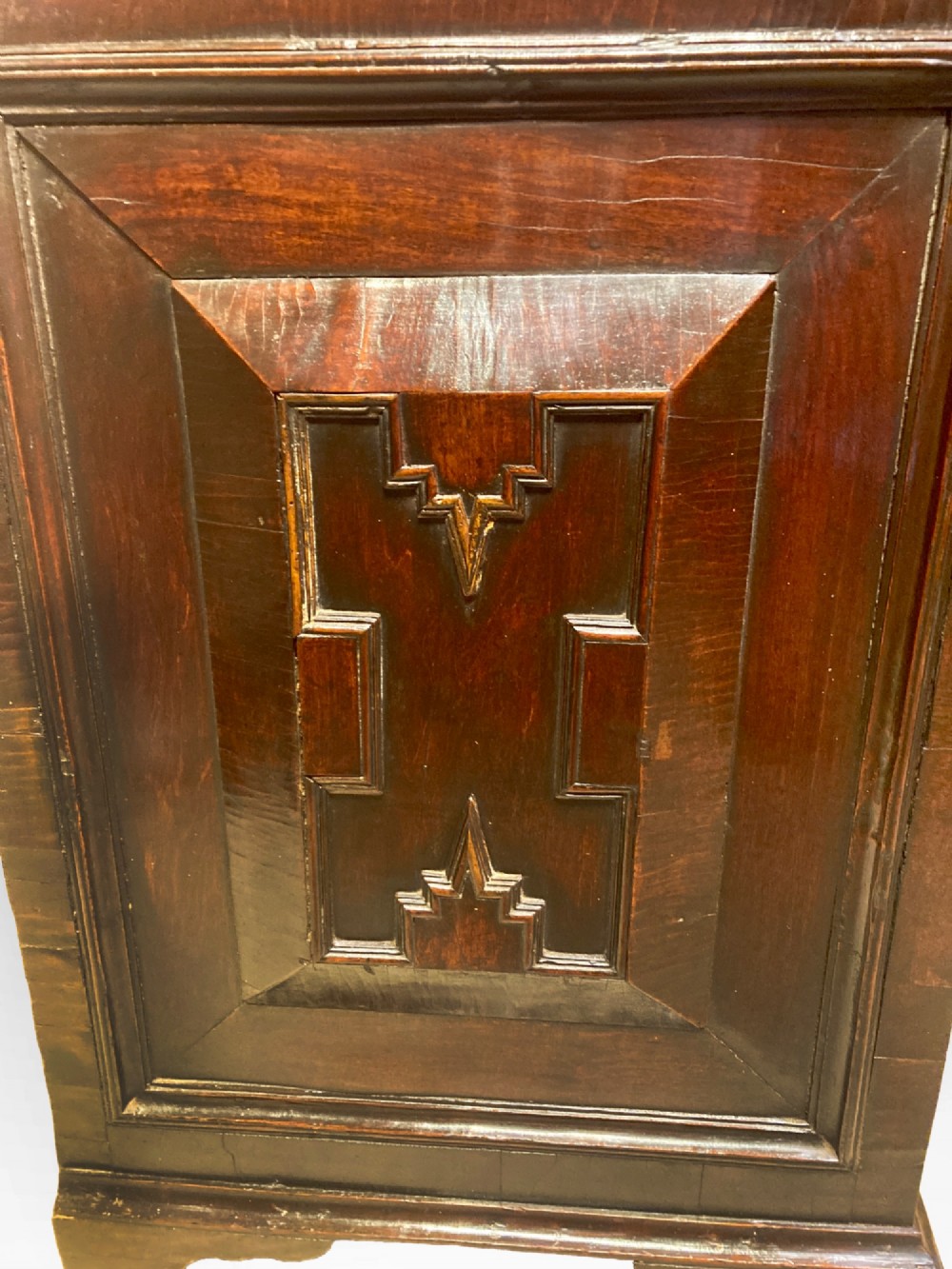 An antique dark brown walnut cupboard with a single top drawer, two fielded panel doors, brass drop handles, and bracket feet. View IV