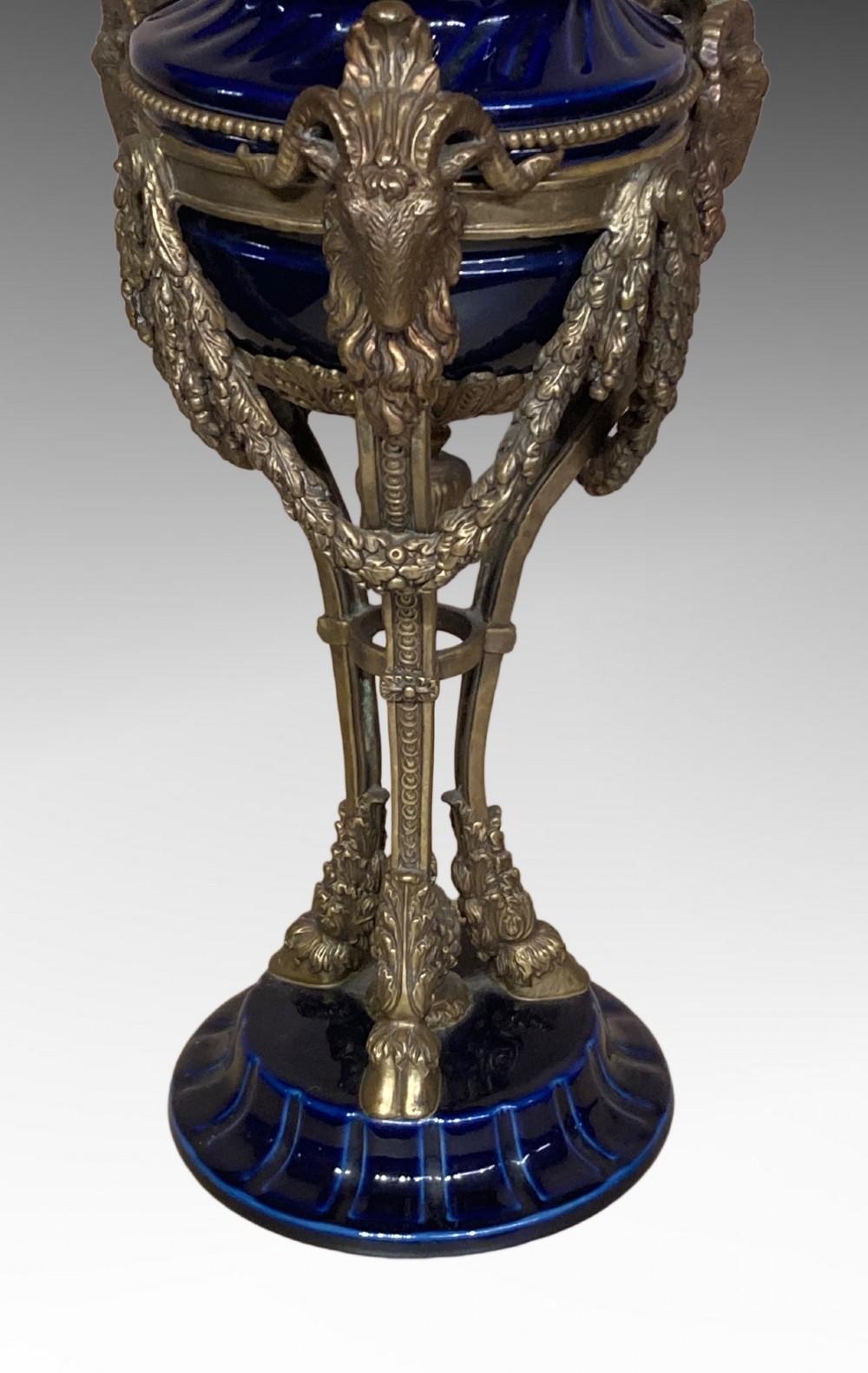 A pair of cobalt blue glazed ceramic urn-shaped table lamps mounted with gilt bronze ram head handles and festoons. View II