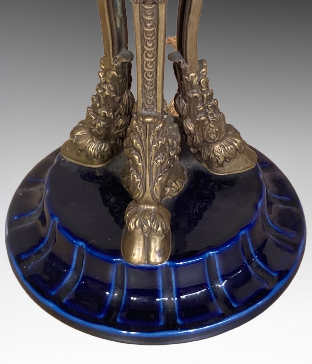A pair of cobalt blue glazed ceramic urn-shaped table lamps mounted with gilt bronze ram head handles and festoons. View III
