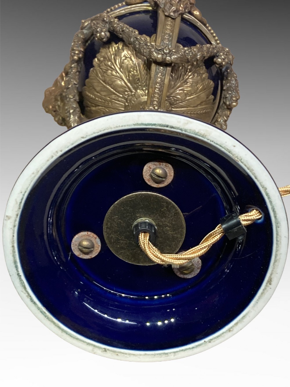 A pair of cobalt blue glazed ceramic urn-shaped table lamps mounted with gilt bronze ram head handles and festoons. View VI