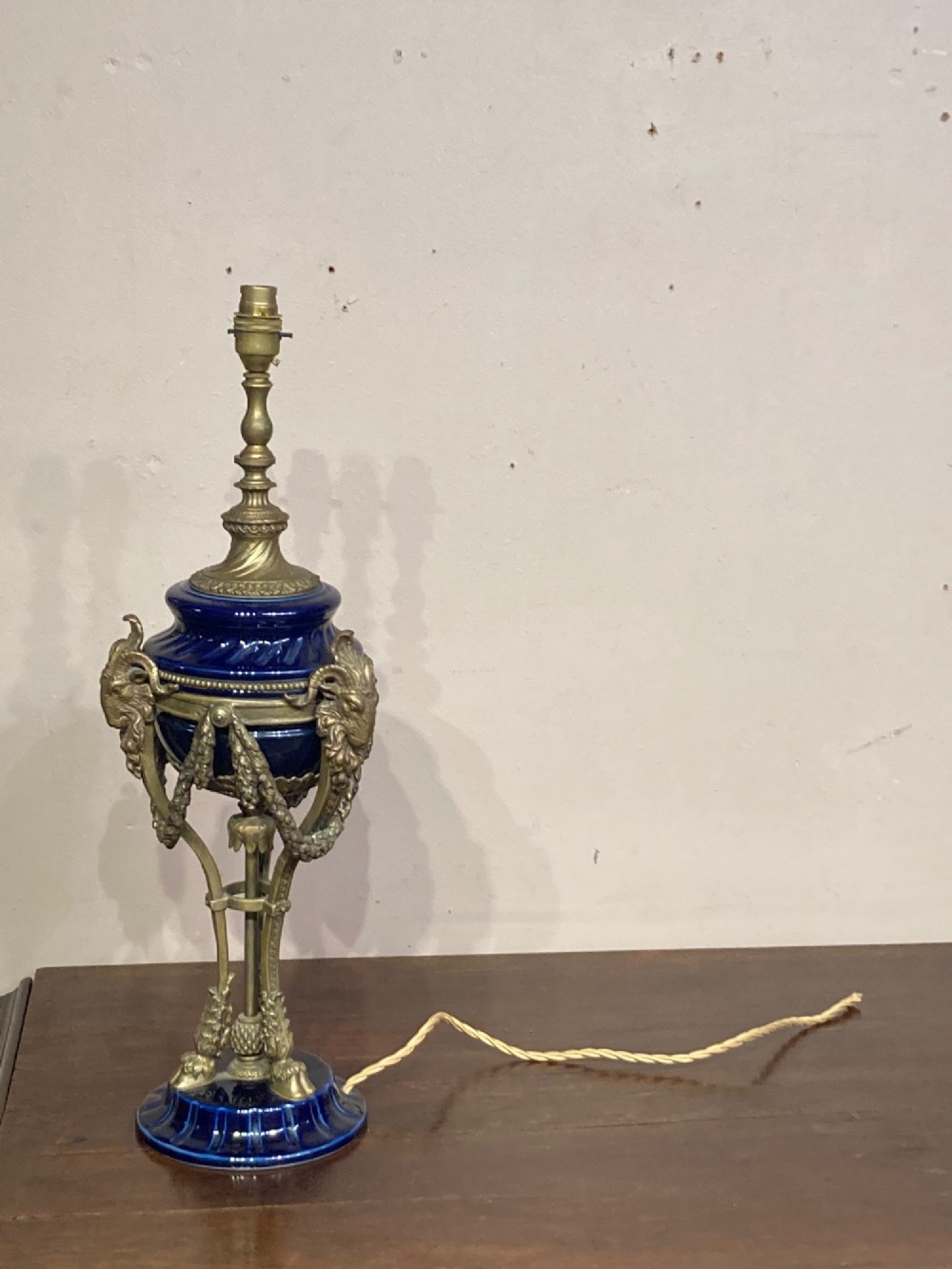 A pair of cobalt blue glazed ceramic urn-shaped table lamps mounted with gilt bronze ram head handles and festoons. View VII