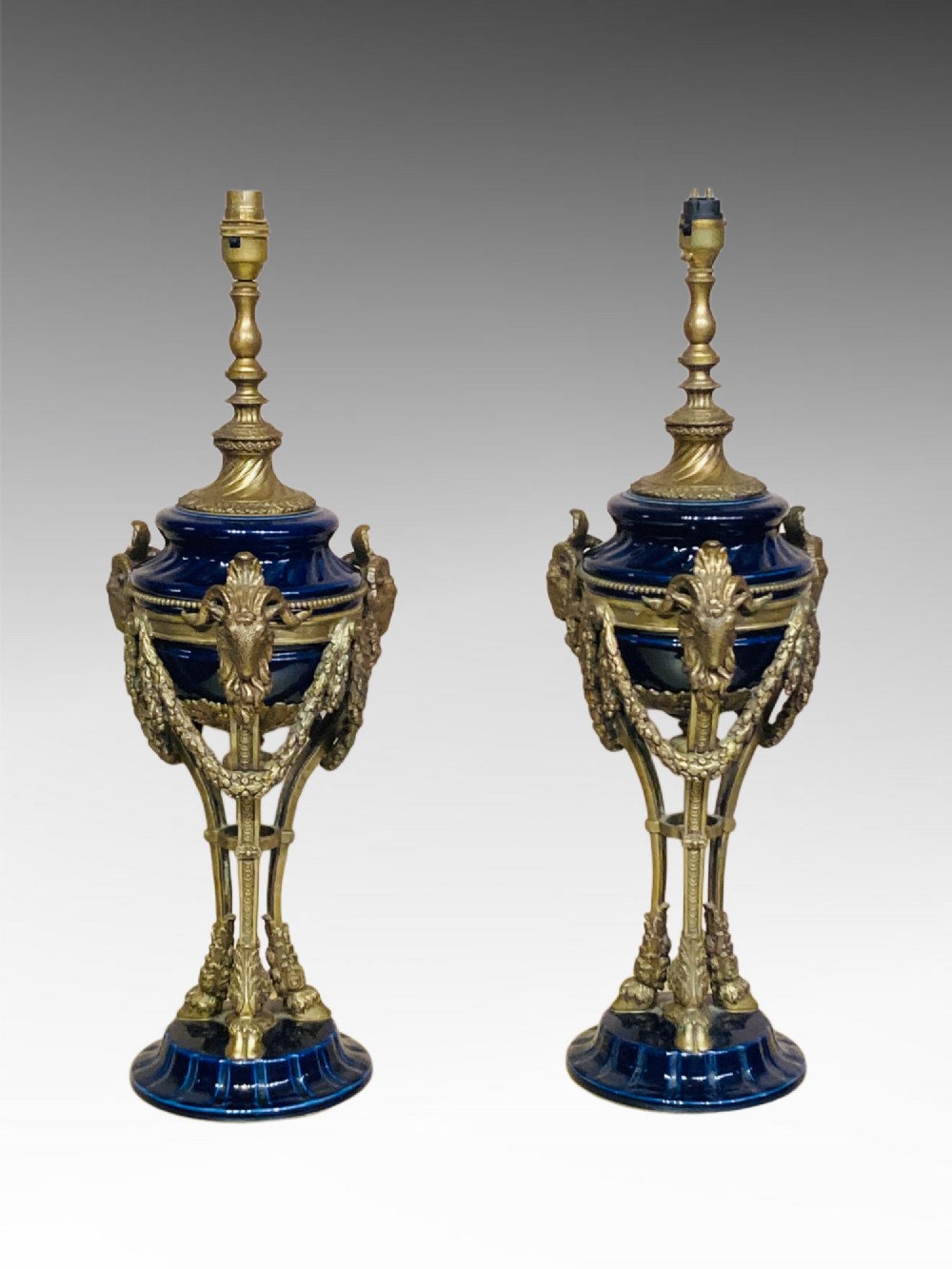 A pair of cobalt blue glazed ceramic urn-shaped table lamps mounted with gilt bronze ram head handles and festoons. View VIII