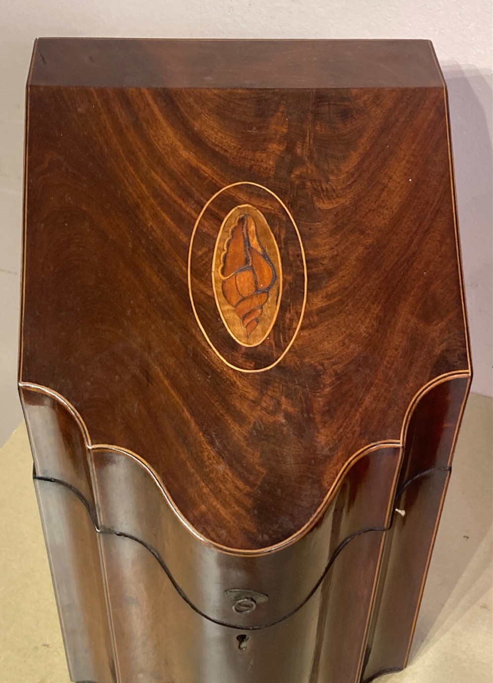 A pair of Georgian mahogany knife boxes featuring sloping lids with oval marquetry shell inlays and serpentine-fronted bodies. View II