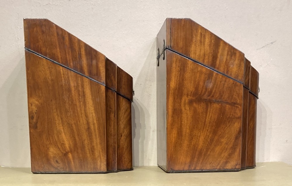 A pair of Georgian mahogany knife boxes featuring sloping lids with oval marquetry shell inlays and serpentine-fronted bodies. View V
