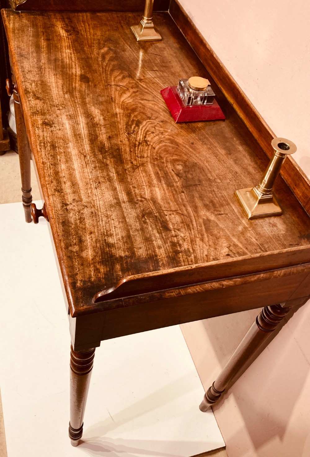 A Georgian mahogany side table featuring a raised gallery top, turned legs, and a single frieze drawer. View II