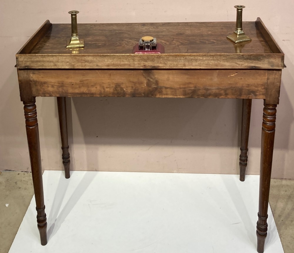 A Georgian mahogany side table featuring a raised gallery top, turned legs, and a single frieze drawer. View IV