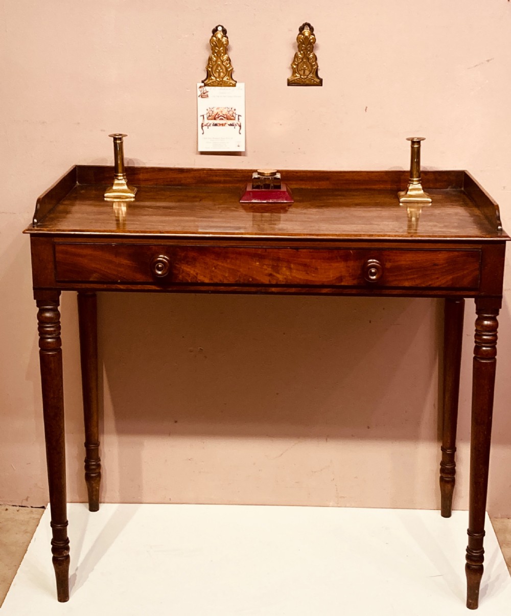 A Georgian mahogany side table featuring a raised gallery top, turned legs, and a single frieze drawer. View VI