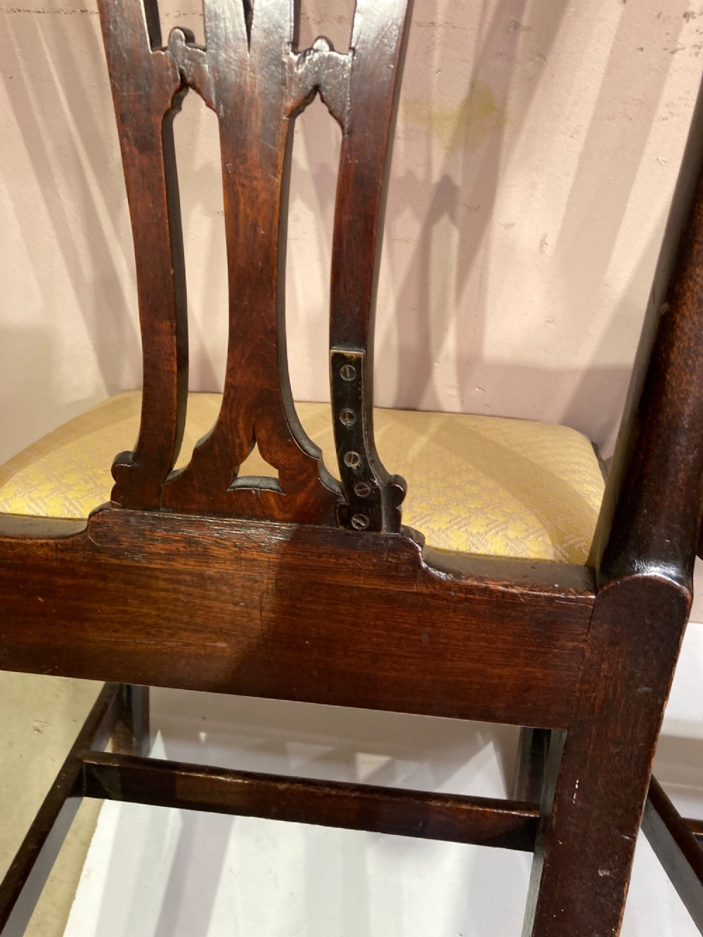 A pair of antique Georgian mahogany side chairs featuring pierced Gothic splat backs, cream upholstered seats, and straight legs connected by stretchers. View IV