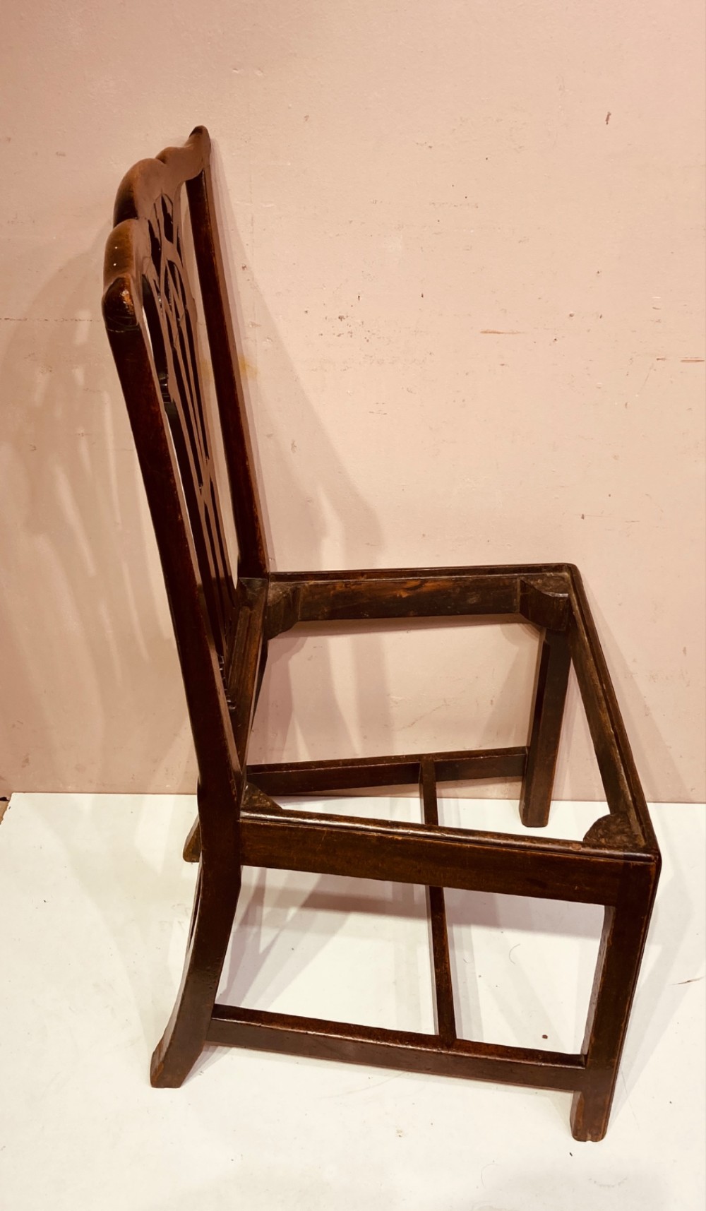 A pair of antique Georgian mahogany side chairs featuring pierced Gothic splat backs, cream upholstered seats, and straight legs connected by stretchers. View V