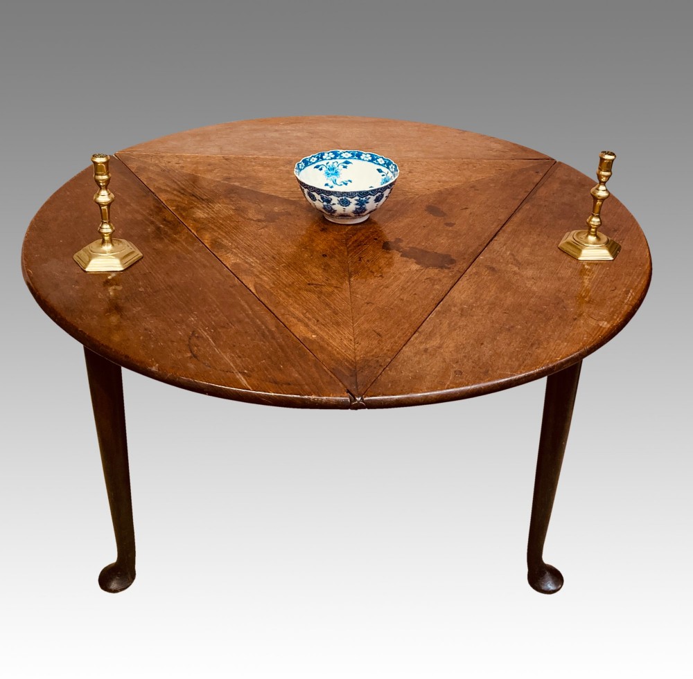 A Georgian red walnut drop-leaf table featuring a triangular top, drop flaps, and turned legs ending in pad feet. View V