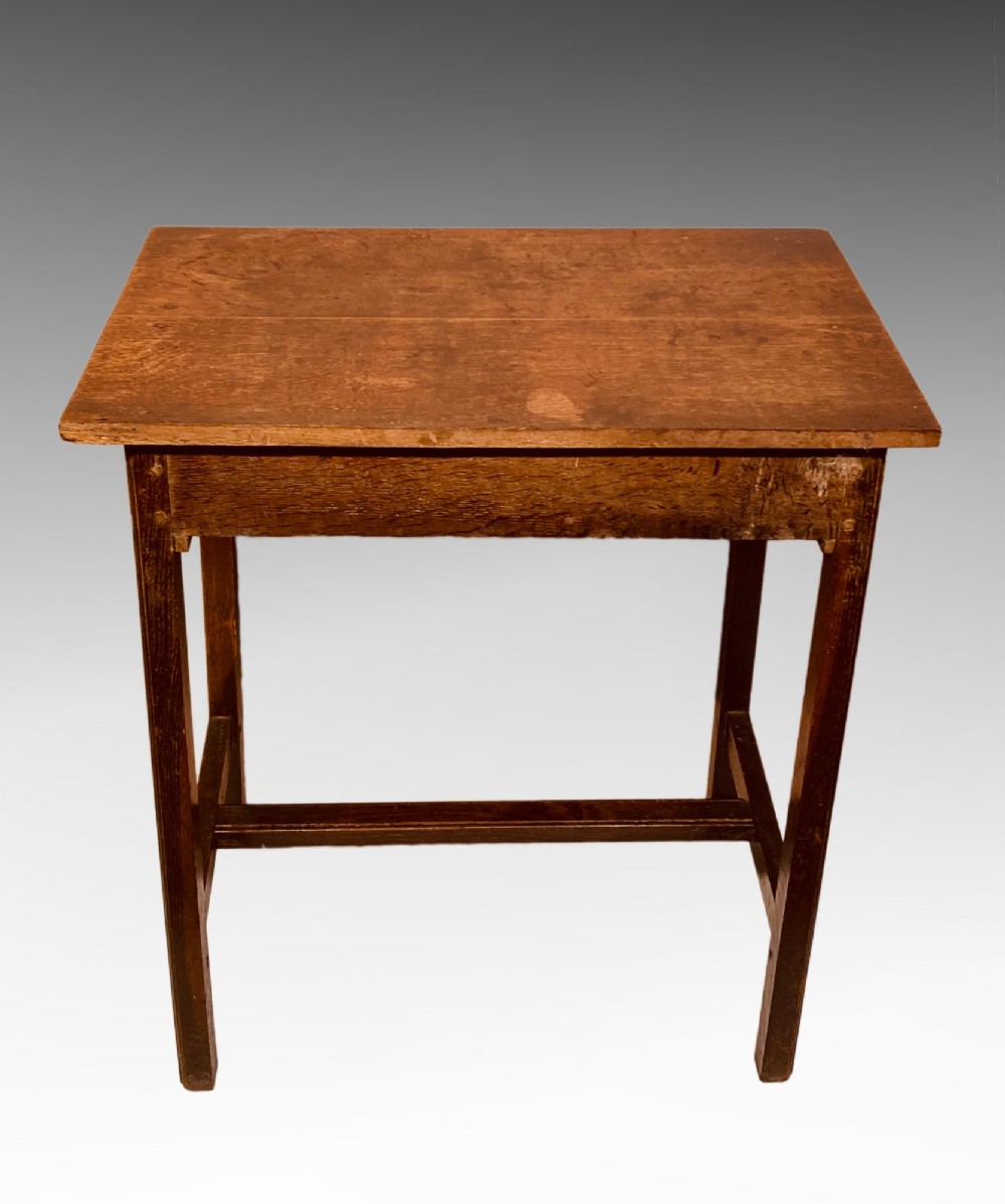 An antique dark oak side table featuring a single drawer with two small brass knobs and square legs connected by stretchers. View III