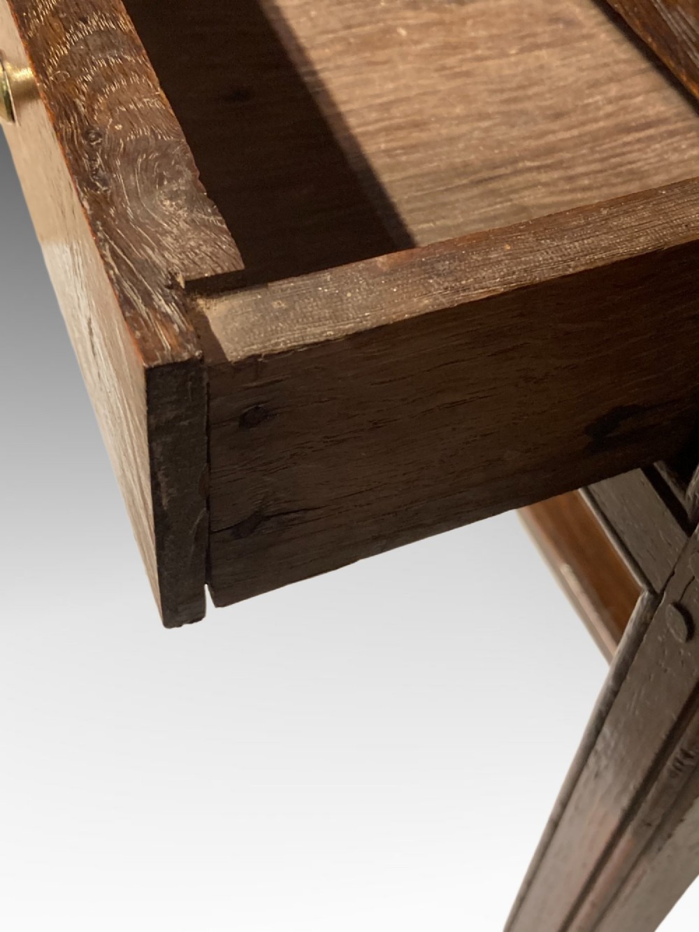 An antique dark oak side table featuring a single drawer with two small brass knobs and square legs connected by stretchers. View VI