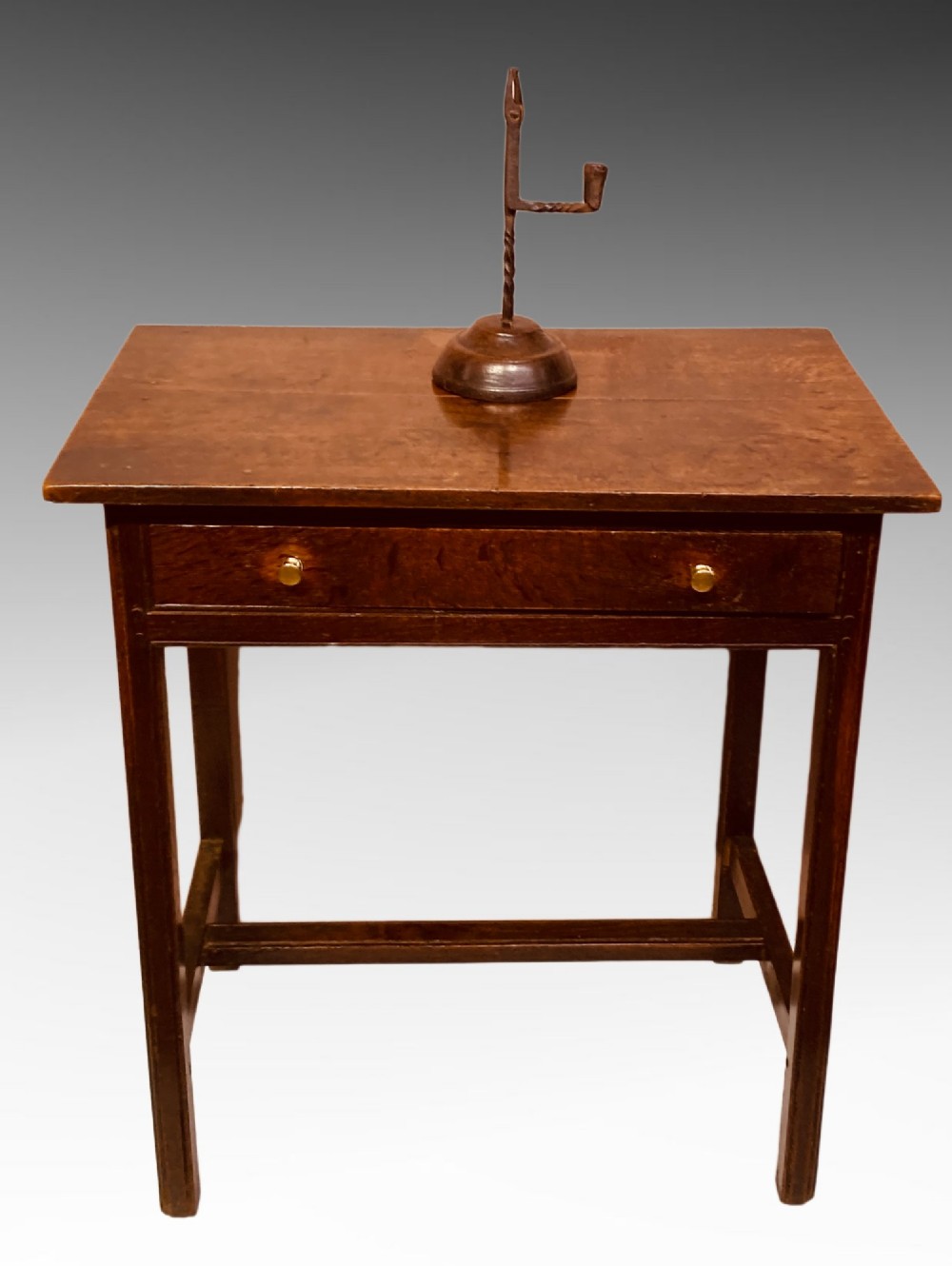 An antique dark oak side table featuring a single drawer with two small brass knobs and square legs connected by stretchers. View IX