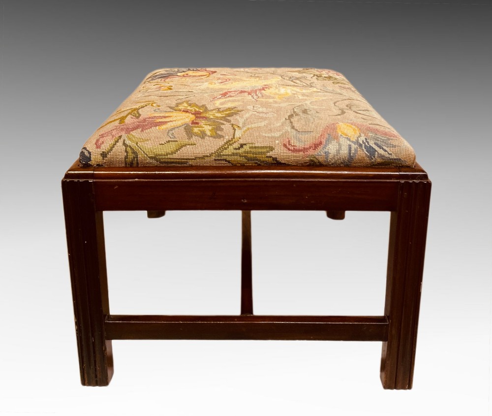 An antique mahogany rectangular dressing stool featuring fluted legs, an H-stretcher base, and a padded floral tapestry seat. View II