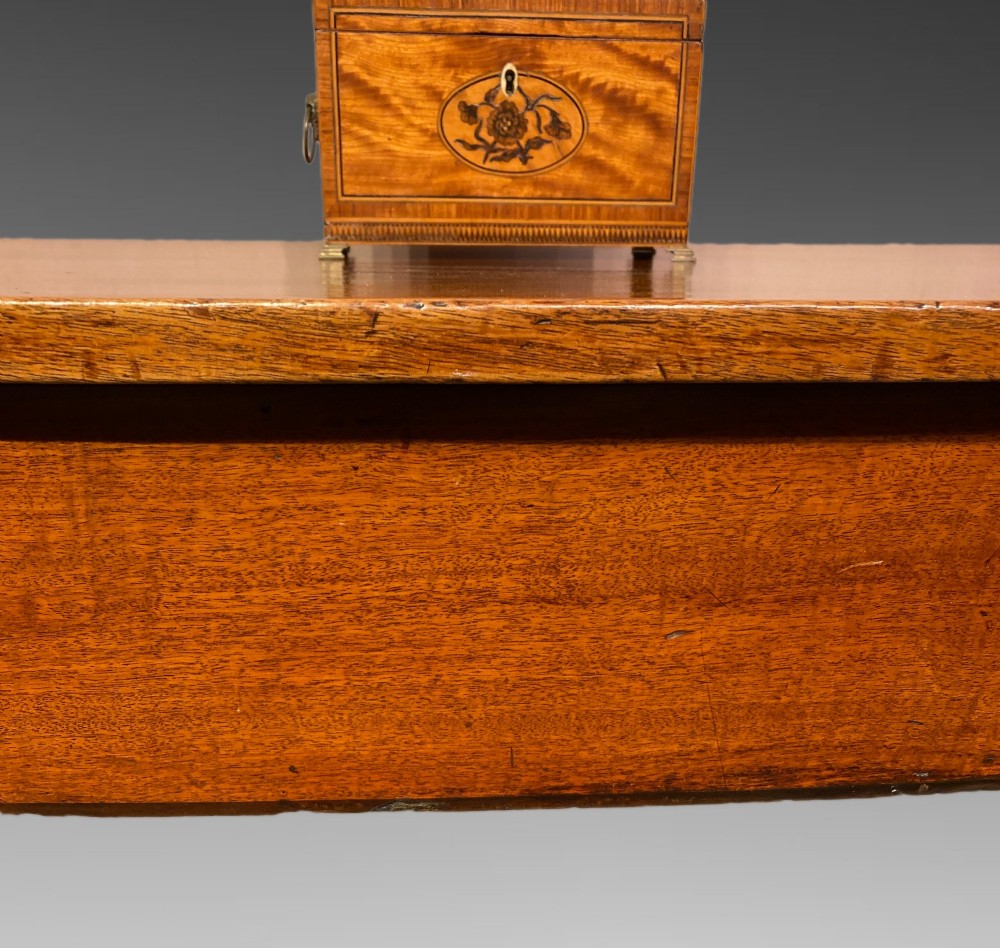 A Georgian mahogany side table featuring a gently curved bow front and four slender square-tapered legs terminating in spade feet. View VII