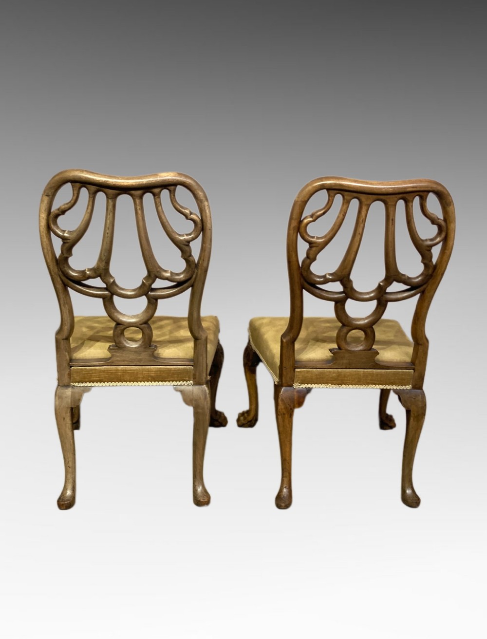 A pair of carved George II style walnut side chairs featuring open shell-form backs, upholstered gold velvet seats, and cabriole legs ending in ball and claw feet. View II