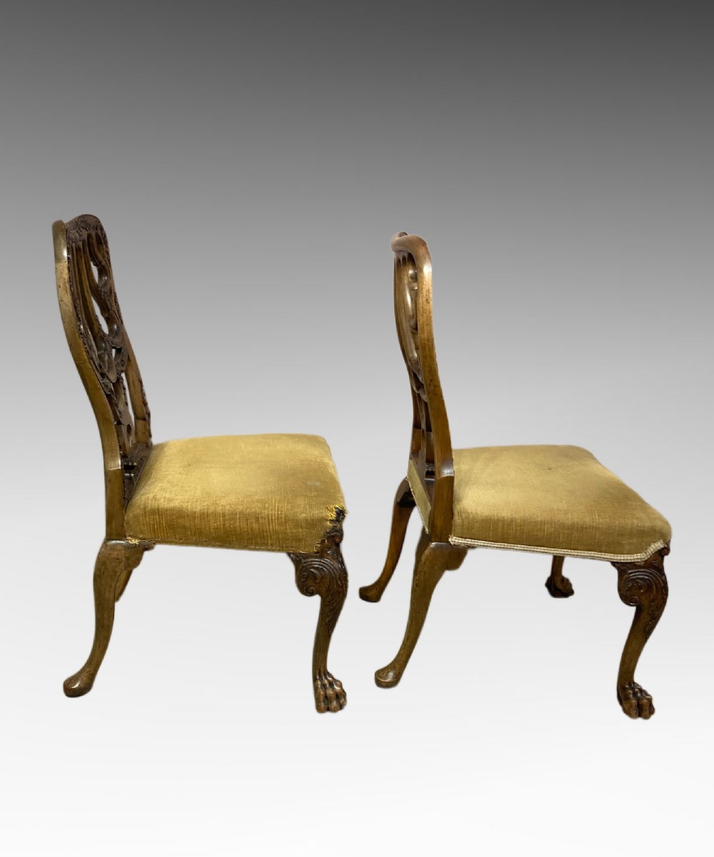 A pair of carved George II style walnut side chairs featuring open shell-form backs, upholstered gold velvet seats, and cabriole legs ending in ball and claw feet. View III