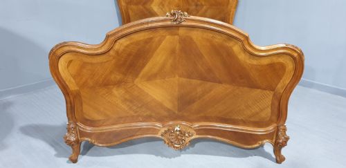 fig 1. A French Louis XV style walnut bed frame featuring quarter-matched veneered panels and parcel gilt hand-carved cresting on the headboard and footboard.
