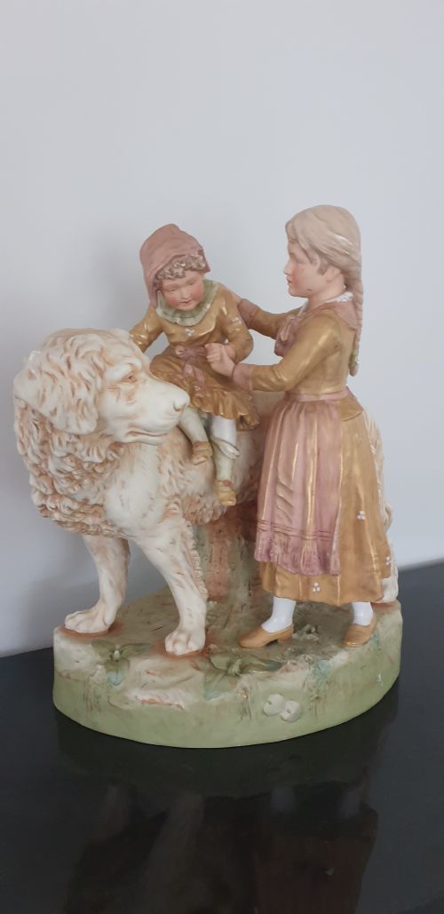 fig 1. An antique Royal Dux porcelain figure group depicting two children interacting with a large dog on a green base.
