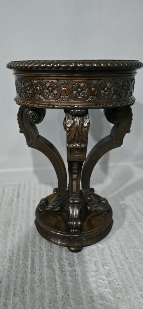 fig 1. A Victorian dark carved timber side table with a circular black marble top featuring an inlaid floral pietra dura motif.