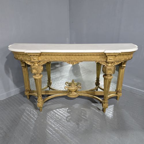fig 1. A Victorian giltwood console table featuring a white marble top, mirrored back panel, fluted tapered legs, and a carved rosette frieze.
