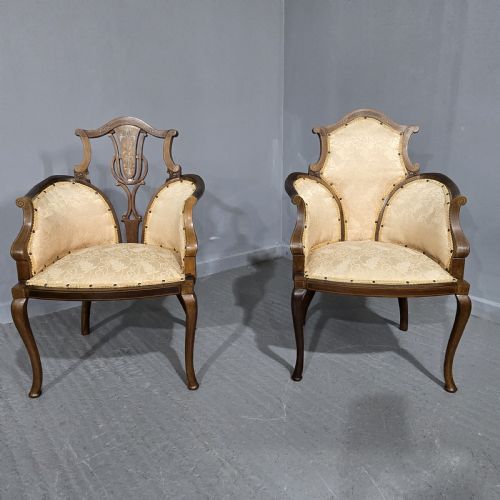 fig 1. A pair of Edwardian Art Nouveau mahogany armchairs featuring cream floral upholstery, decorative back splats with marquetry inlay, and curved legs.