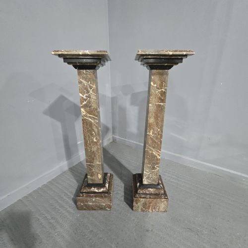 fig 1. A pair of tall French rouge marble columns with square stepped capital tops, black marble collars, and square plinth bases.