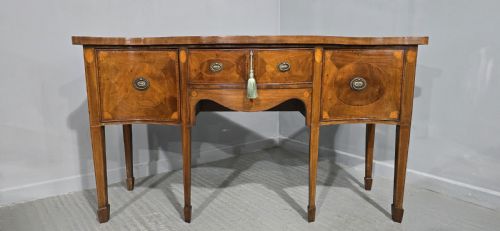 fig 1. An Edwardian mahogany sideboard featuring satinwood inlay, oval fan motifs, central drawers, flanking cupboards, and slender tapered legs.