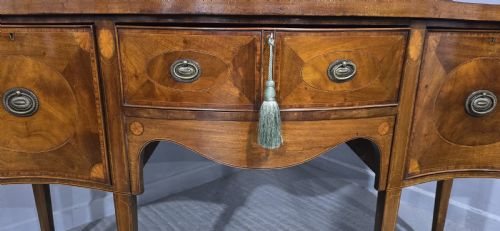 fig 2. An Edwardian mahogany sideboard featuring satinwood inlay, oval fan motifs, central drawers, flanking cupboards, and slender tapered legs.