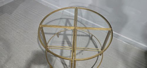 fig 1. A set of four quadrant-shaped gold brass tables with glass tops arranged together to form a single circular surface.